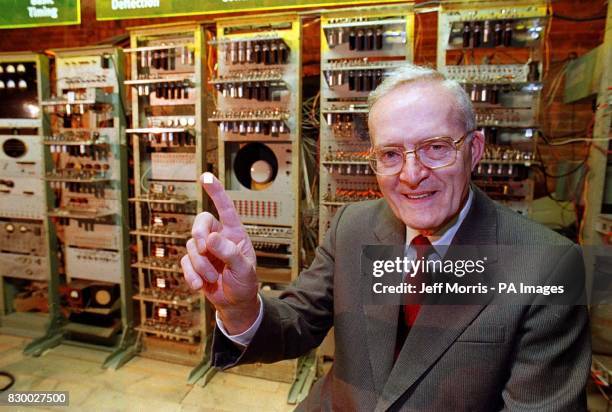 Professor Tom Kilburn with tiny modern day computer 'chip' on his finger, whilst in the background is "Baby" - the worlds first computer which Prof...