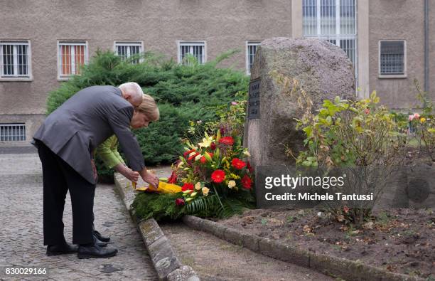 German Chancellor Angela Merkel and with former Prisoner Arno Defke lay a wreath while she visits the former prison of the East German, communist-era...