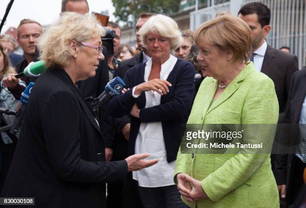 German Chancellor Angela Merkel speaks with visitors as she visits the former prison of the East German, communist-era secret police, or Stasi, at...