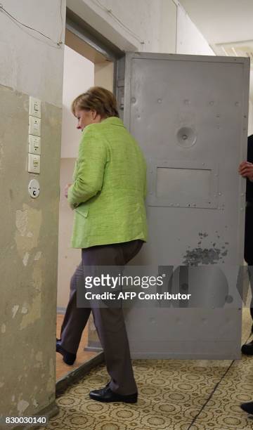 German Chancellor Angela Merkel enters a cell as she visits the Berlin-Hohenschönhausen Memorial at the site of a former prison of the East German...