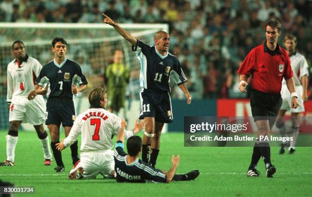 England's David Beckham protests his innocence before being shown the red card by referee Kim Milton Neilsen for kicking Diego Simeone of Argentina