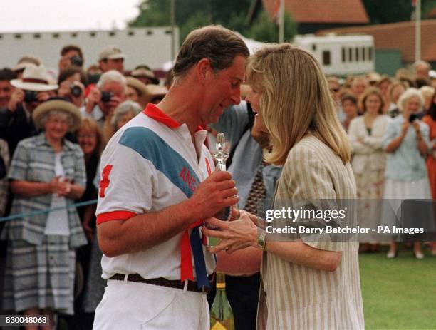 The Prince of Wales receives a consolation kiss by Lady Romsey as he receives a losers' trophy after playing for Ansty against Emlor in the...