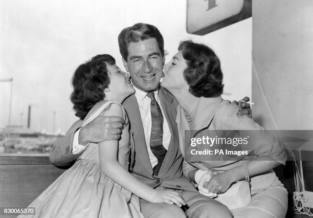 PA NEWS PHOTO 10/8/58 ACTOR DERMOT WALSH GETS A GOODBYE KISS FROM HIS WIFE HAZEL COURT AND DAUGHTER SALLY AT HEATHROW AIRPORT, LONDON BEFORE HE...