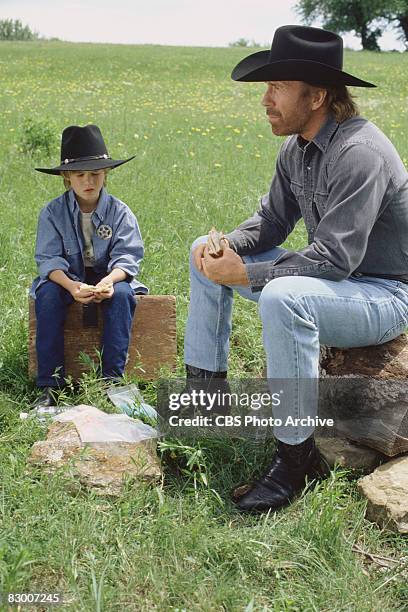 American actor Chuck Norris and Haley Joel Osment sit outdoors in a scene from an episode the television series 'Walker, Texas Ranger' entitled...