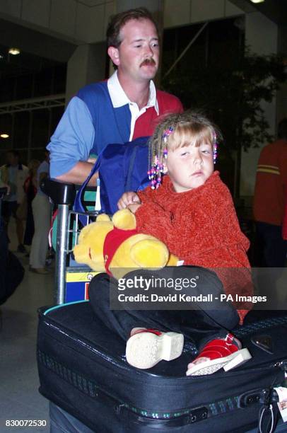 Paul Benson and daughter Samantha aged 5, arrive at Manchester Airport from Florida early this morning as the full might of Hurricane Georges...
