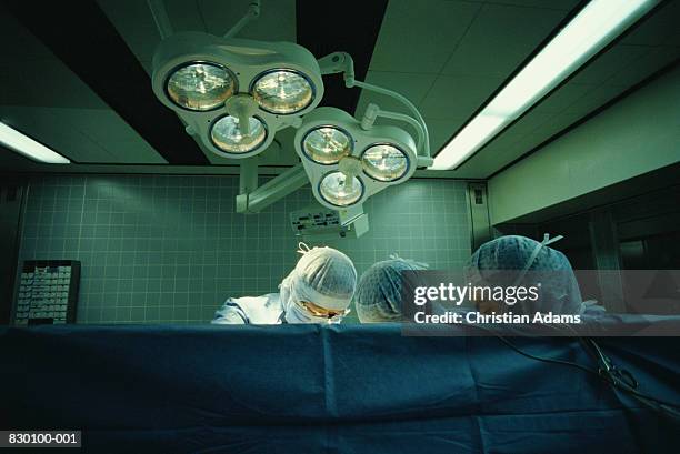 three surgeons in operating theatre, high section - operating room foto e immagini stock