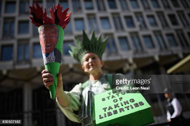 Woman dressed as "The Statue of Taking Liberties" poses outside the U.S. Embassy during a "Stop the War" protest on August 11, 2017 in London,...