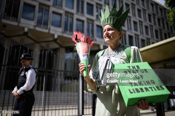 Woman dressed as "The Statue of Taking Liberties" poses outside the U.S. Embassy during a "Stop the War" protest on August 11, 2017 in London,...