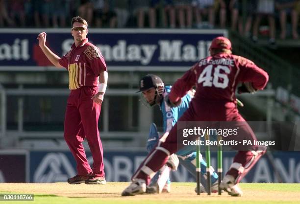 Queensland bowler Stuart Law throws the ball to keeper Wade Seccombe as England Captain Adam Hollioake narrowly avoids being run-out during a match...