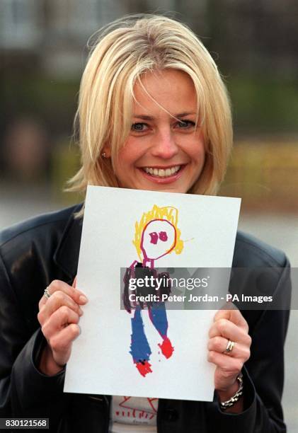 Presenter Ulrika Jonsson with a portrait of herself drawn by her four-year-old, Cameron Turnball today at the launch of Oil of Ulay's search to 'Make...