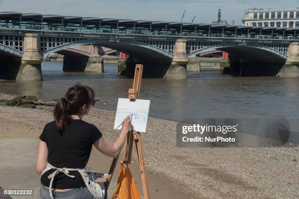 Painter is pictured while painting the Blackfriars bridge, in a sunny morning in the Southbank of London, on August 11, 2017. The South Bank is an...