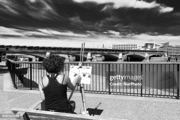 Painter is pictured while painting the Blackfriars bridge, in a sunny morning in the Southbank of London, on August 11, 2017. The South Bank is an...