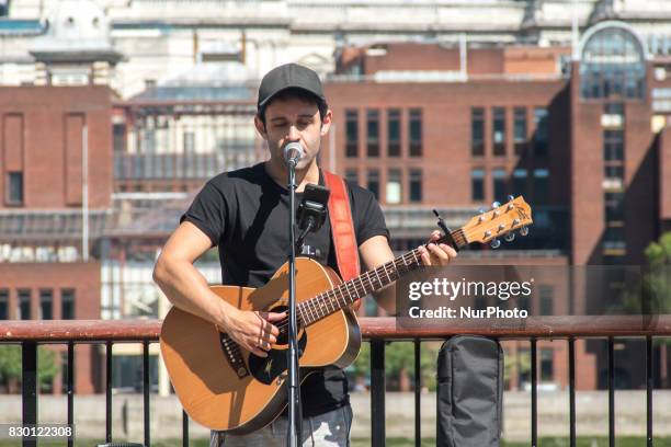 Pusker is pictured while he performs, against the backdrop of St. Paul's Cathedral, in a sunny morning in the Southbank of London, on August 11,...