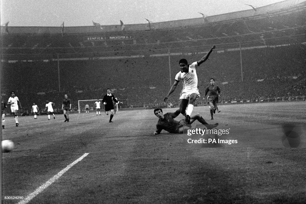 PA NEWS PHOTO 29/5/68  EUSEBIO OF BENFICA TRIES A SHOT AT GOAL IN THE EUROPEAN CUP FINAL AT WEMBLEY STADIUM, LONDON. ON THE GROUND IS DAVID SADLER OF MANCHESTER UNITED. UNITED WON 4-1   (Photo by PA Images via Getty Images)