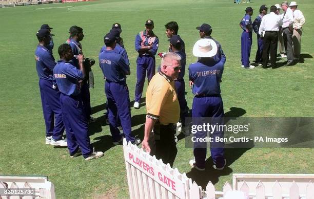 The Sri Lankan team wait as captain Arjuna Ranatunga tries to resolve matters after bowler Muttiah Muralitharan was called for chucking by umpire...