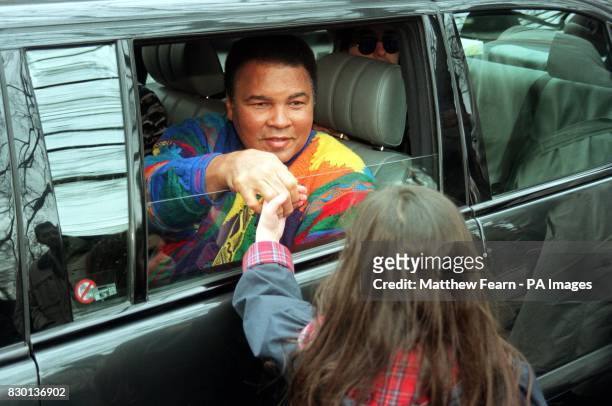 Boxing legend Muhammad Ali shakes the hand of a little girl after he laid a wreath at a monument in London as part of a campaign by the Jubilee 2000...