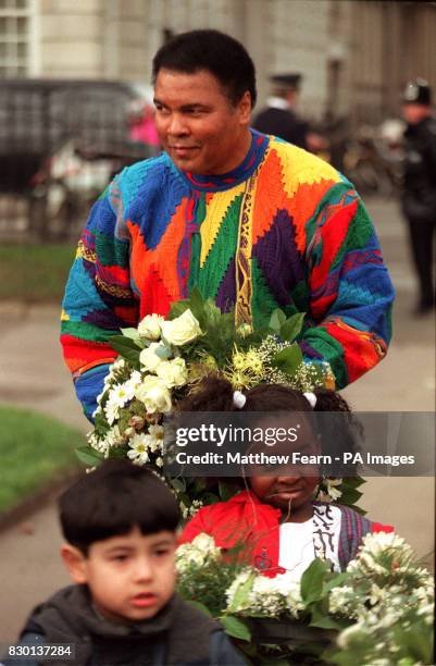 Boxing legend Muhammad Ali with some children before he lays a wreath at a monument in London as part of a campaign by the Jubilee 2000 Coalition to...