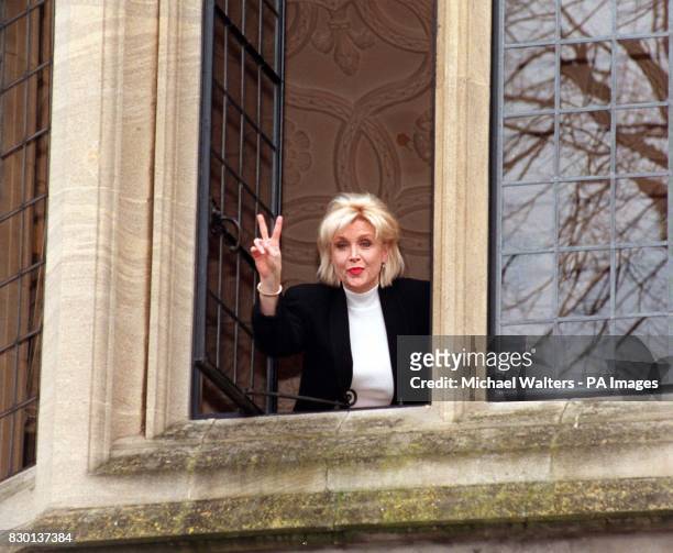 Gennifer Flowers, who had an infamous liaison with US President Bill Clinton, gestures a peace 'V' sign from a window at Oxford University , where...