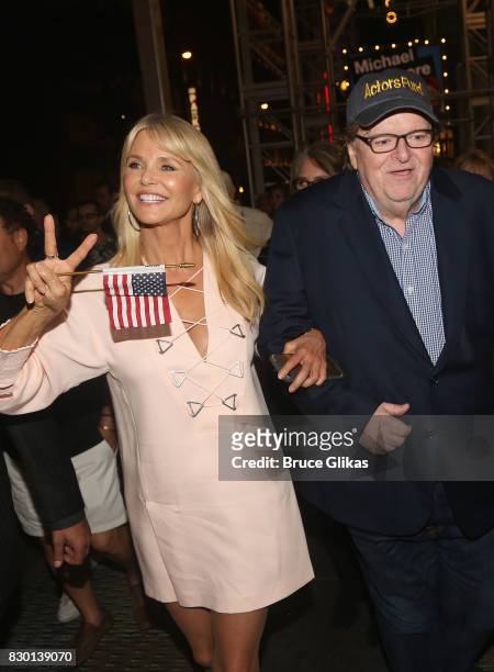 Christie Brinkley and Michael Moore walk in a parade of celebration to the opening night party for "Michael Moore: "The Terms Of My Surrender" on...
