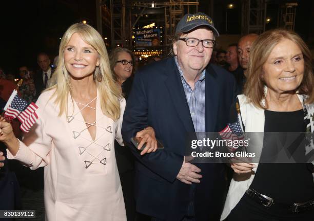 Christie Brinkley, Michael Moore and Gloria Steinem walk in a parade of celebration to the opening night party for "Michael Moore: "The Terms Of My...
