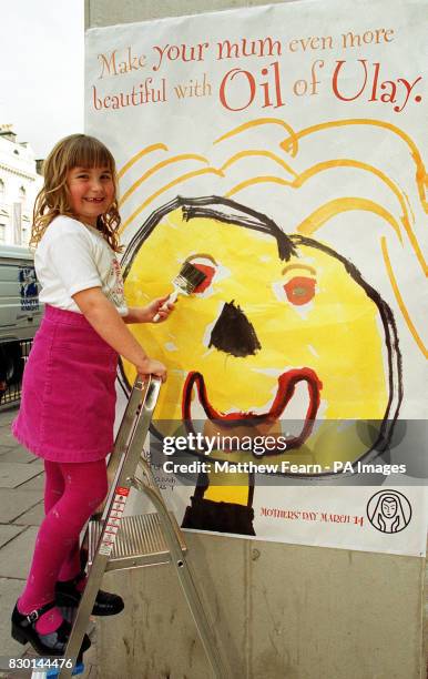Seven-year-old Hannah Mills from Preston, Lancashire, pastes her award-winning poster of her mother on to its first site on Kensington High Street,...