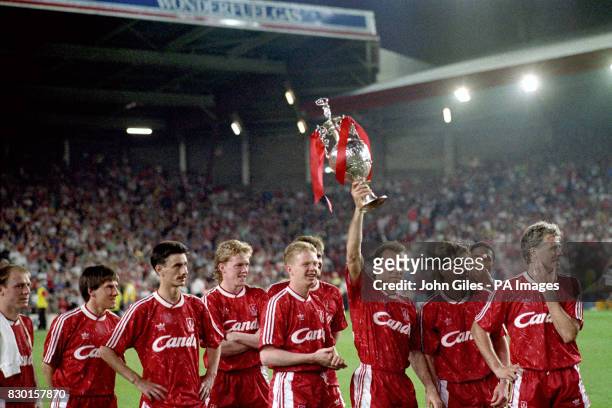 Liverpool striker Ronny Rosenthal holds aloft one of the two league championship trophies at Anfield, after his side defeated Derby County 1-0, as he...
