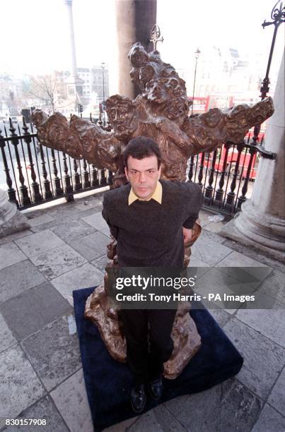 Romanian artist Dr Doru Imbroane Marculescu' with his statue of Jesus Christ outside St Martin-in-Fields Church in Trafalgar Square, London, which...