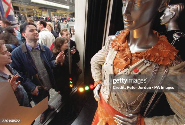 Shoppers in London's Oxford Street view the original costumes worn by Abba on the night the group won the 1974 Eurovision Song Contest, on display at...