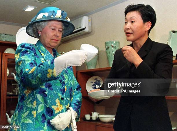 The Queen is shown a celadon cup, during a visit to a pottery shop in Seoul, South Korea. Celadon is a grey-green glaze used on pottery. The Queen...