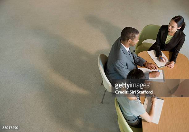 office workers at meeting table - meeting table stock pictures, royalty-free photos & images