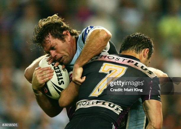 Brett Kimmorley of the Sharks takes on the Storm defence during the first NRL Preliminary Final match between the Cronulla Sharks and the Melbourne...