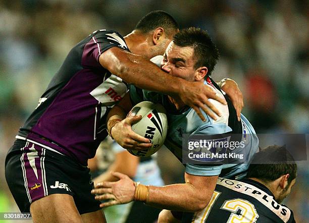 Luke Douglas of the Sharks is hit high by the Storm defence during the first NRL Preliminary Final match between the Cronulla Sharks and the...