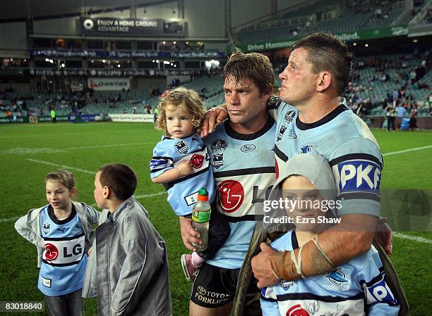 Danny Nutley and Brett Kimmorley of the Sharks stand with their children after losing the first NRL Preliminary Final match between the Cronulla...