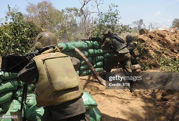 This picture taken on September 22, 2008 shows Sri Lankan government troops firing in the forward defence line in the Karambukulam village in...