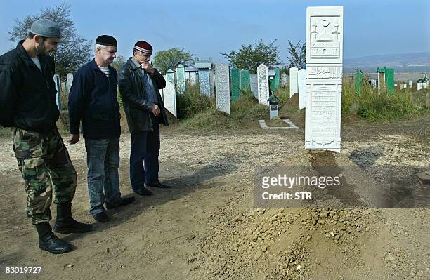 Chechen men look on the the grave of Russia's former Duma deputy Ruslan Yamadayev in Gudermes on September 26, 2008. Ruslan Yamadayev was gunned down...