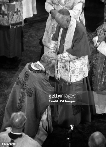 George Basil Hume former Abbot of Ampleforth, kneels before His Eminence Cardinal William Conway, Primate of All Ireland, during the ceremony in...