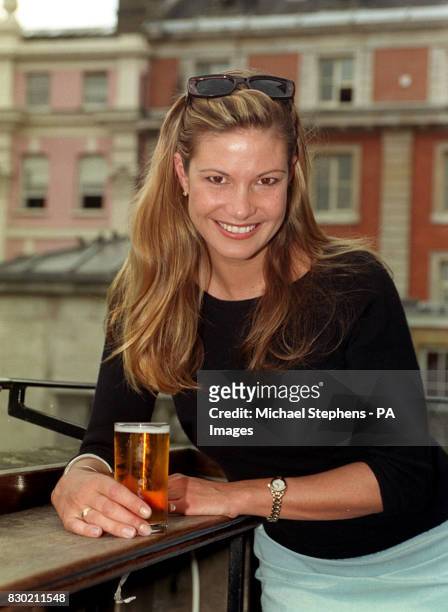 Mimi MacPherson, sister of supermodel Elle and the 'Face of Fosters', holds a glass of the lager during a photocall on the balcony of the Punch &...