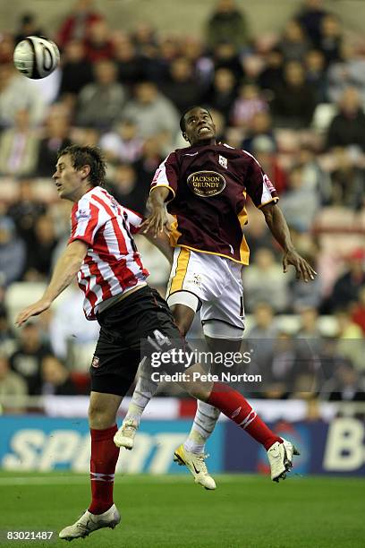 Liam Davis of Northampton Town contests the ball with Daryl Murphy of Sunderland during the Carling Cup Third Round Match between Sunderland and...