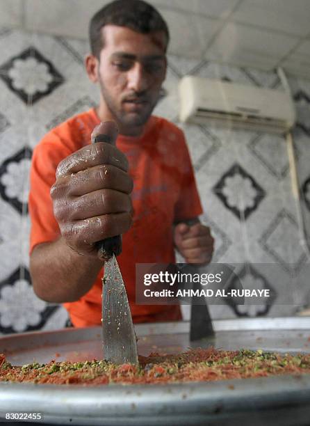 Bakery employee cuts pieces of "kunafa", a traditional Middle Eastern dessert, in Baghdad's Karrada district on September 1, 2008. Prime Minister...