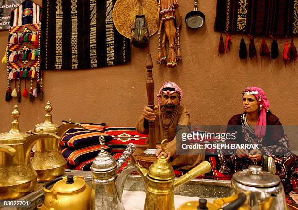 Couple in traditional bedouin constume prepare Arabic coffee on September 2, 2008 for customers who flood Beirut's cafes and hotels after the break...