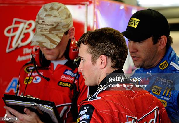 Kasey Kahne, driver of the Budweiser Dodge looks on as his crew chief Kenny Francis and Elliott Sadler driver of the Best Buy Dodge exchange...