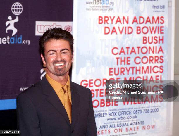 Pop singer George Michael smiles during a press conference in London, where he outlined his involvement with NetAid, a charity concert to be held at...