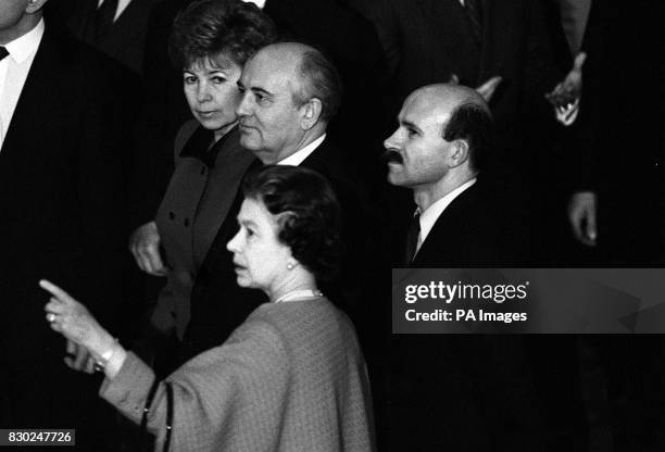 Queen Elizabeth II points out portraits lining the walls of the Waterloo Chamber to Soviet President Mikhail Gorbachev, and his wife Raisa, at...