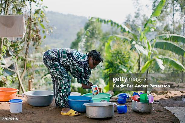 amputee washing dishes outside her house, bukavu - south kivu stock pictures, royalty-free photos & images