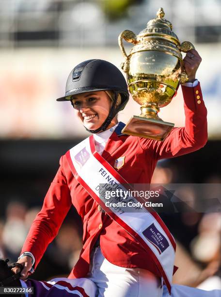 Dublin , Ireland - 11 August 2017; Lillie Keenan of USA lifts the Aga Khan Trophy after winning the FEI Nations Cup during the Dublin International...