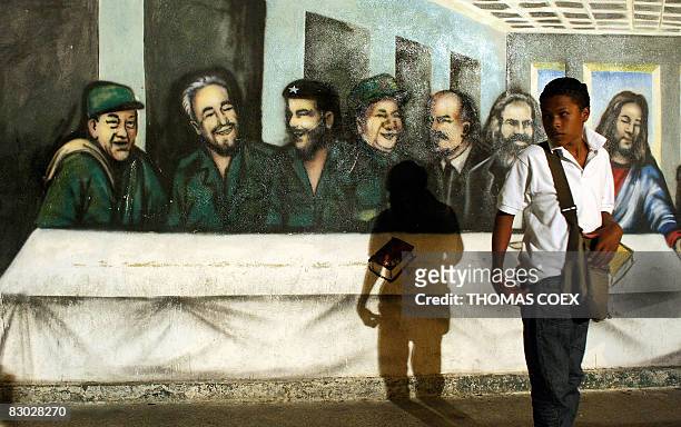 Venezuelan boy passes in front of a mural representing "The Last Supper" with leftist world leaders replacing the apostoles during a ceremony which...