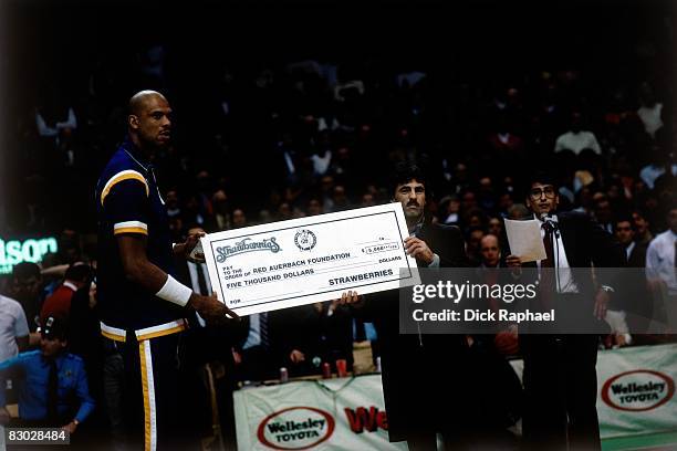 Kareem Abdul Jabbar of the Los Angeles Lakers is presented a check by the Red Auerbach Foundation prior to a game against the Boston Celtics circa...