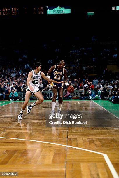 Kareem Abdul Jabbar of the Los Angeles Lakers moves the ball up court against Marc Acres of the Boston Celtics during a game circa 1989 at the Boston...