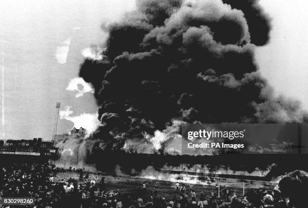 Pall of smoke hangs over the main stand at the Valley Parade football ground December 5, 1985 as it is engulfed by flames during the Bradford City v...