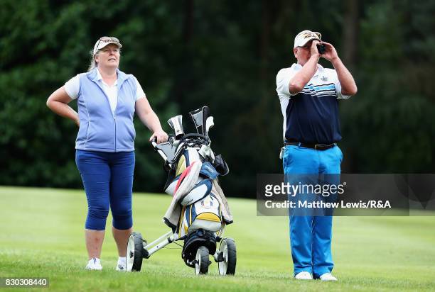 Bryan Hughes of Hesketh looks on with his wife during The Seniors Amateur Championship at Sunningdale Golf Club on August 11, 2017 in Sunningdale,...